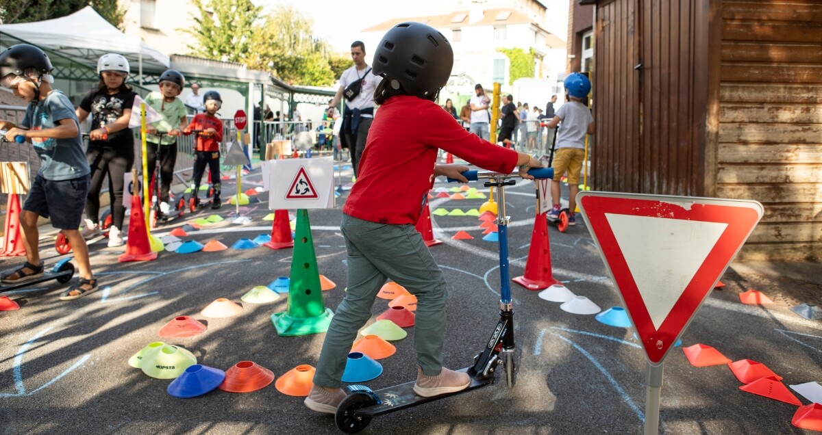 rue-aux-enfants Un enfant faisant une course en trottinette