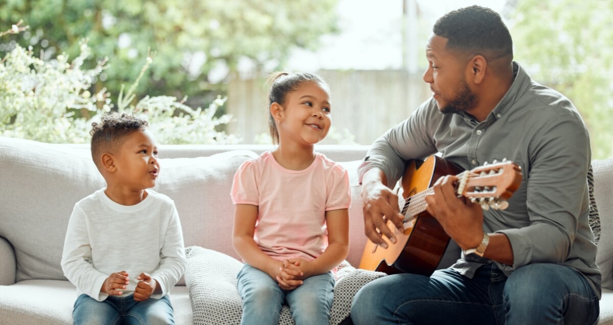 Une famille qui joue tous ensemble sur la même guitare